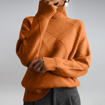 Person wearing a brown turtleneck sweater with geometric pattern on a plain background