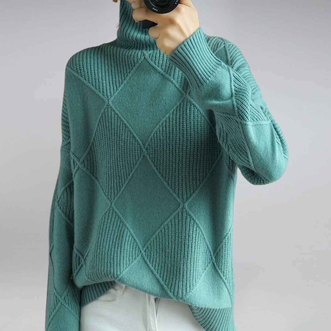 Teal knitted sweater worn by a person on a plain background
