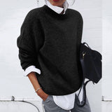 Person wearing a black sweater over a white shirt with a black backpack against a white background